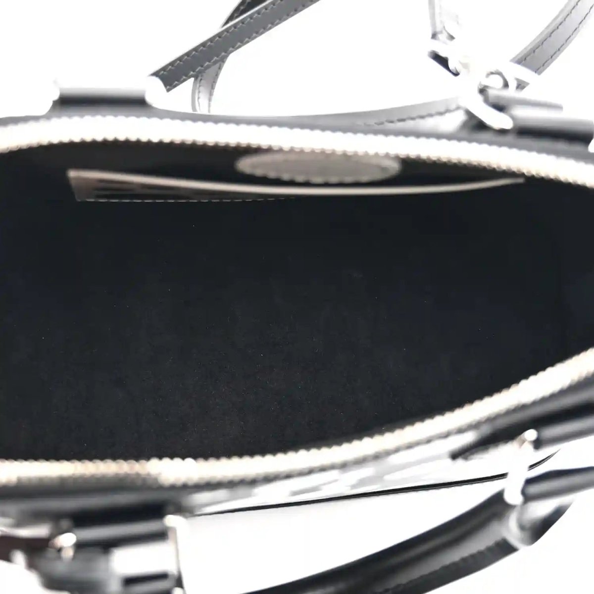 Alma BB bag zipper close-up with metal teeth and black leather trim over interior lining