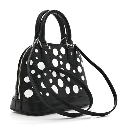 Alma BB bag with black polka-dot exterior, silver zipper, double top handles, strap