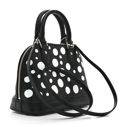 Alma BB bag with black polka-dot exterior, silver zipper, double top handles, strap