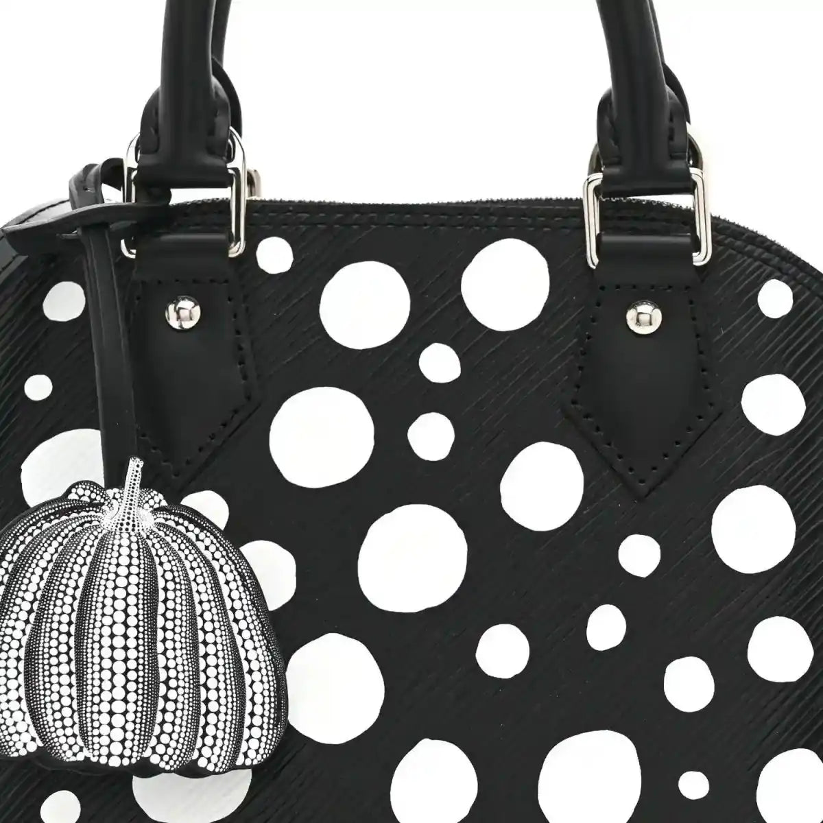 Alma BB bag front with white polka dots, black top handles, and pumpkin charm on clip