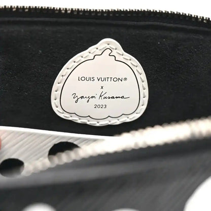 Alma BB bag charm label reading “Louis Vuitton x Yayoi Kusama 2023” on stitched oval