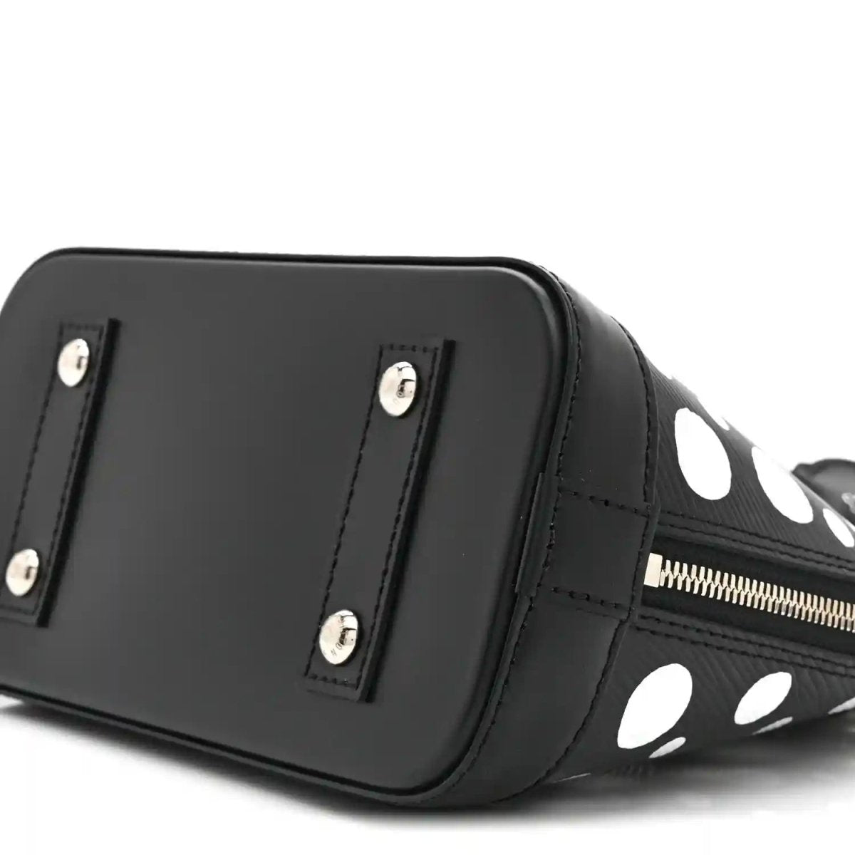 Alma BB bag angled side with smooth black panel, silver studs, and polka-dot trim