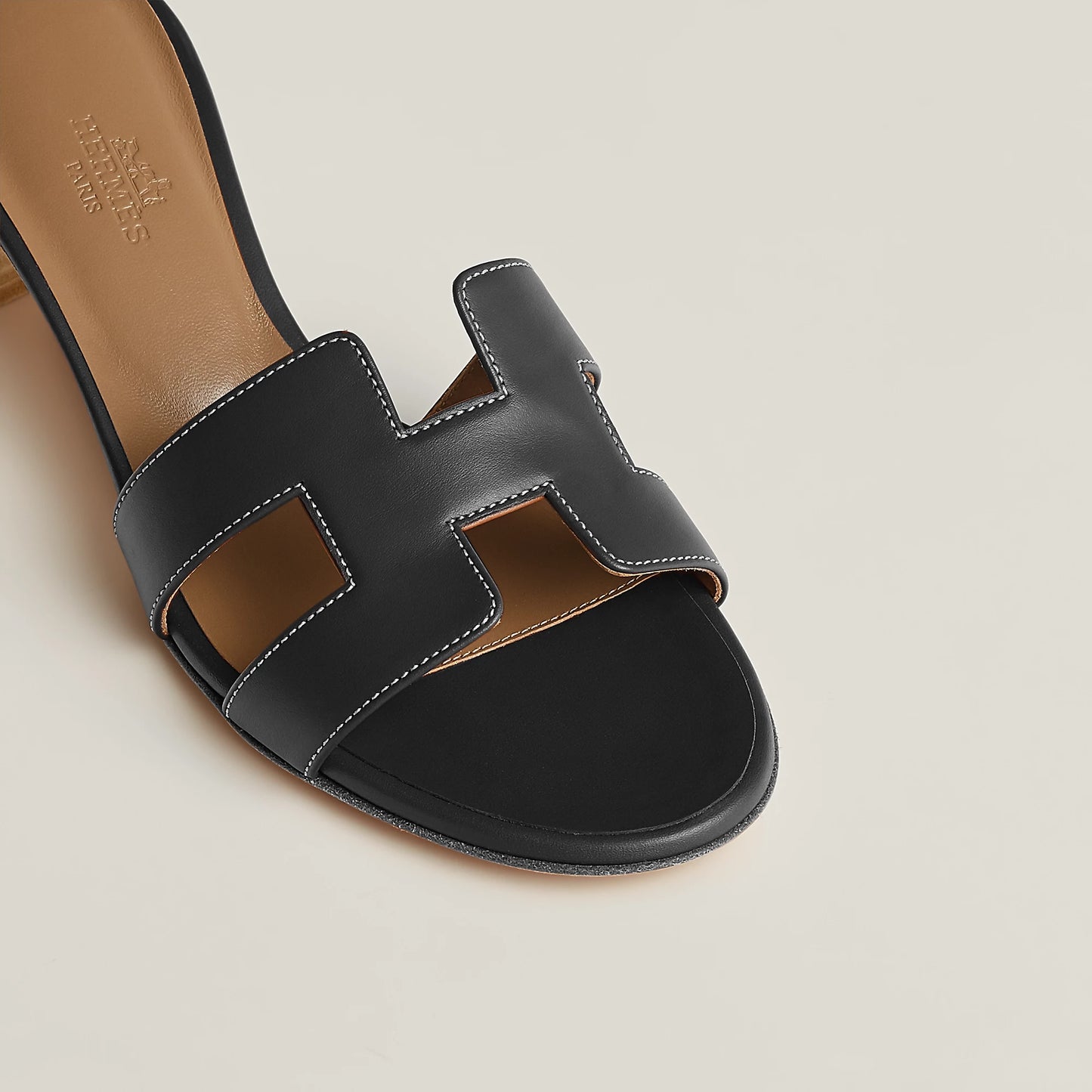 Hermès Oasis sandal in black leather, close-up of H-strap design and white contrast stitching