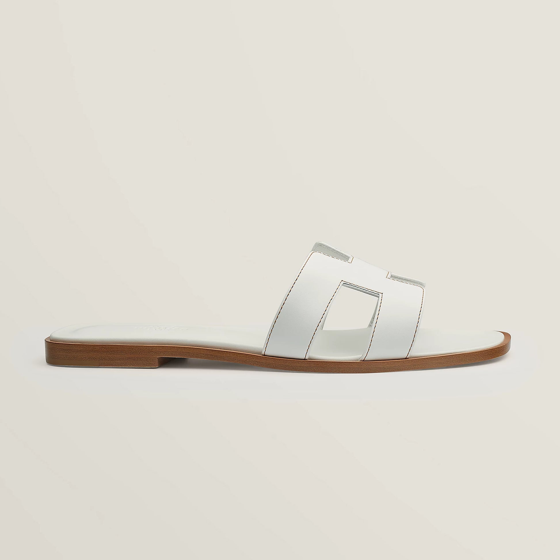 White leather slide sandal with two wide straps and stitched H-style cutouts