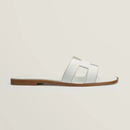 White leather slide sandal with two wide straps and stitched H-style cutouts