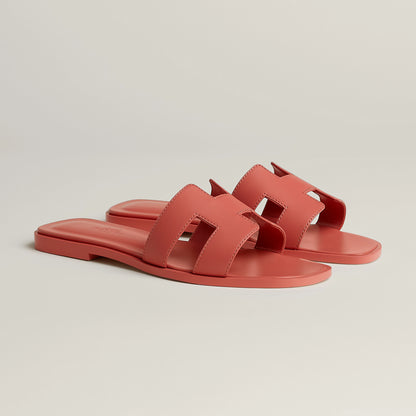 Red leather slide sandal with two wide straps, open toe, and flat sole
