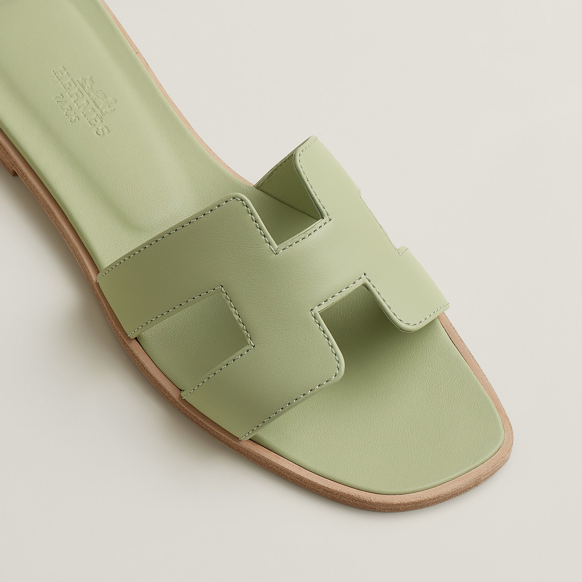 Oran slide sandal close-up in pale mint leather with cutout H-style straps