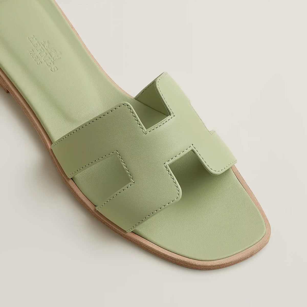 Oran slide sandal close-up in pale mint leather with cutout H-style straps