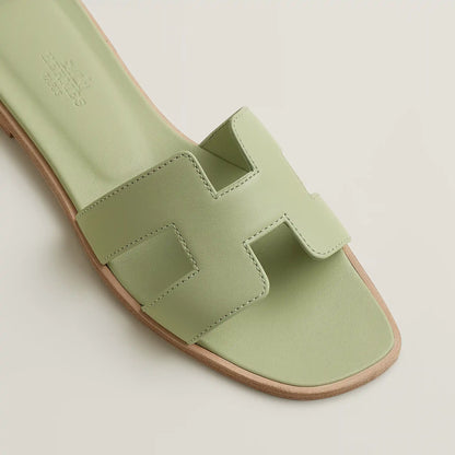 Oran slide sandal close-up in pale mint leather with cutout H-style straps