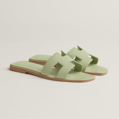 Oran slide sandal angle view in pale mint leather with open toe and tan sole