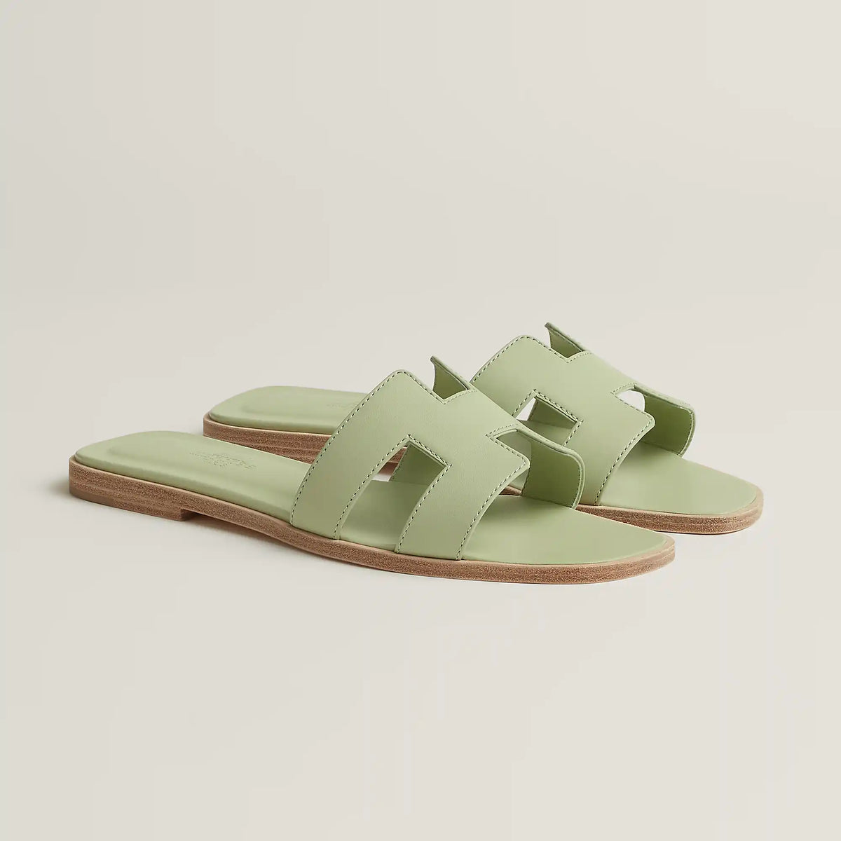Oran slide sandal angle view in pale mint leather with open toe and tan sole