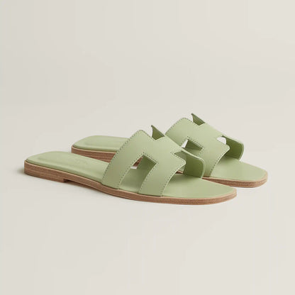 Oran slide sandal angle view in pale mint leather with open toe and tan sole