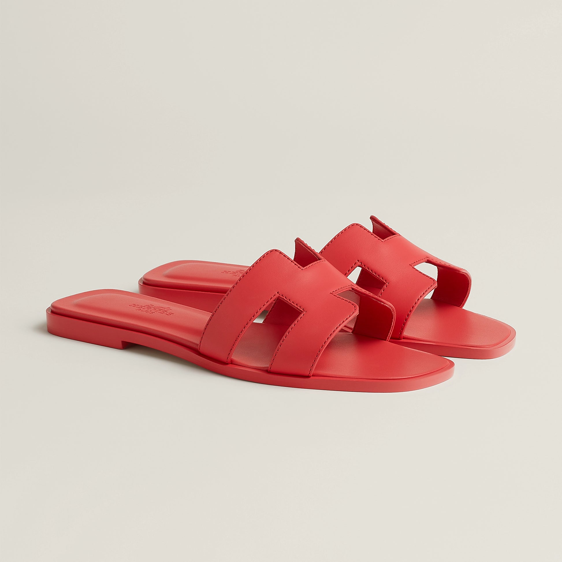 Oran slide sandal side view in bright red leather with double straps and flat sole