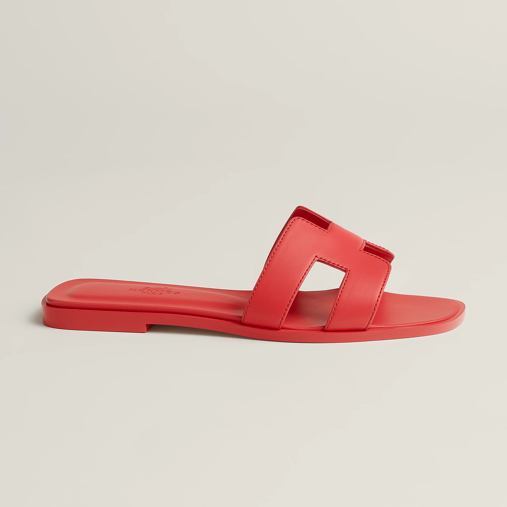 Red leather slide sandal, single visible footbed, open toe with two strap cutouts