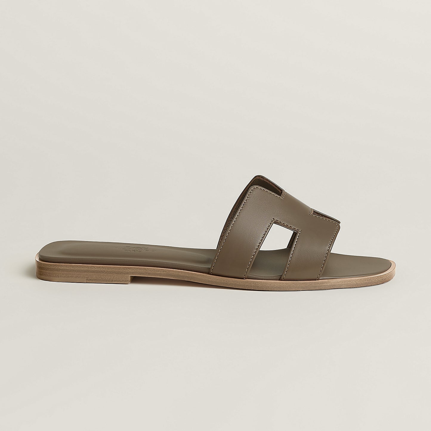 Beige leather slide sandal with two wide straps and open toe, flat sole