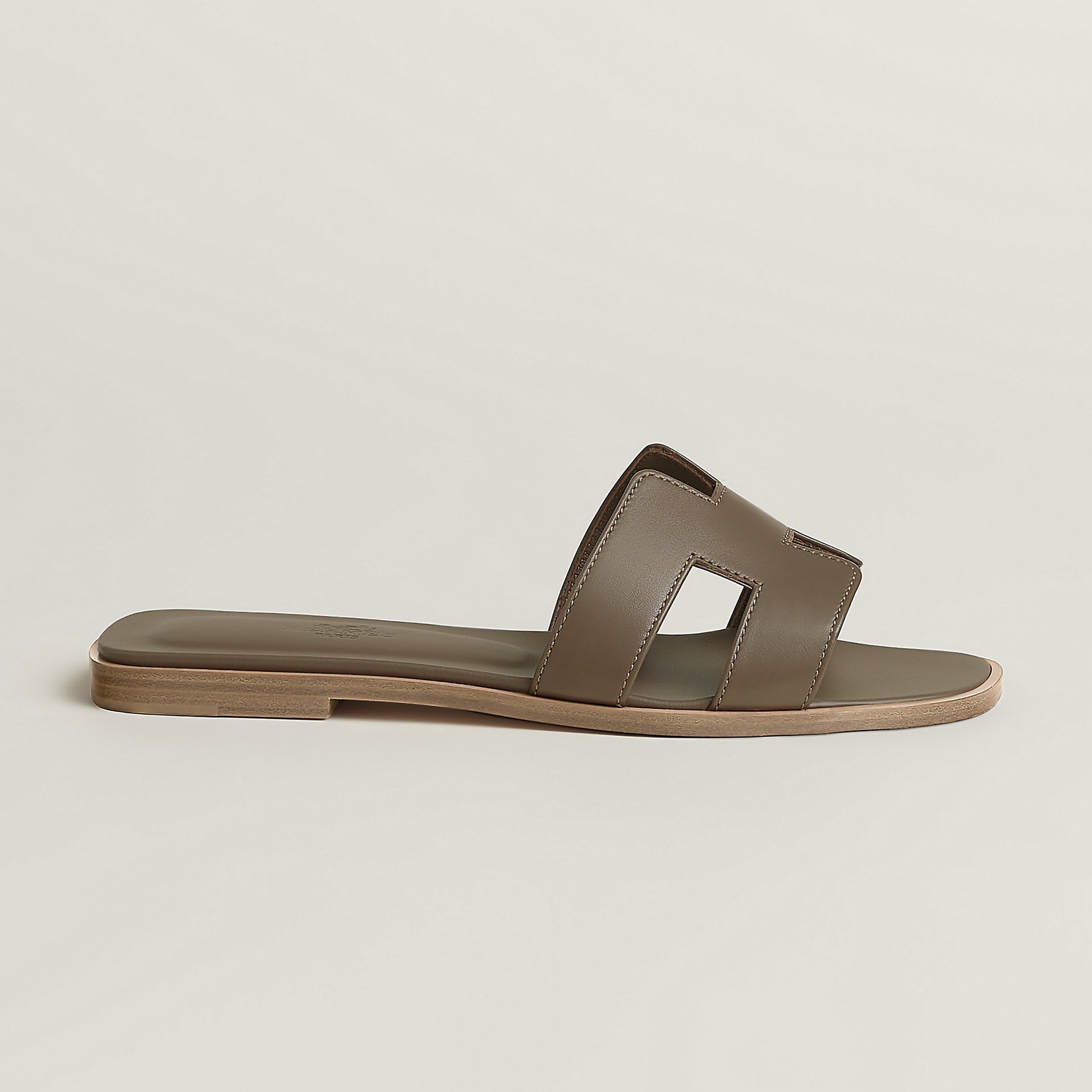 Beige leather slide sandal with two wide straps and open toe, flat sole