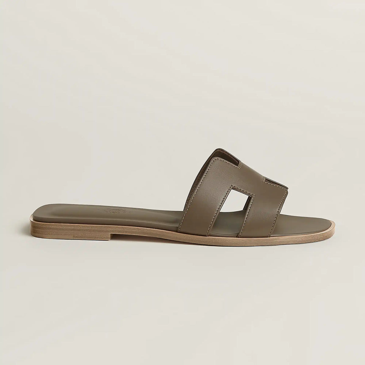 Beige leather slide sandal with two wide straps and open toe, flat sole