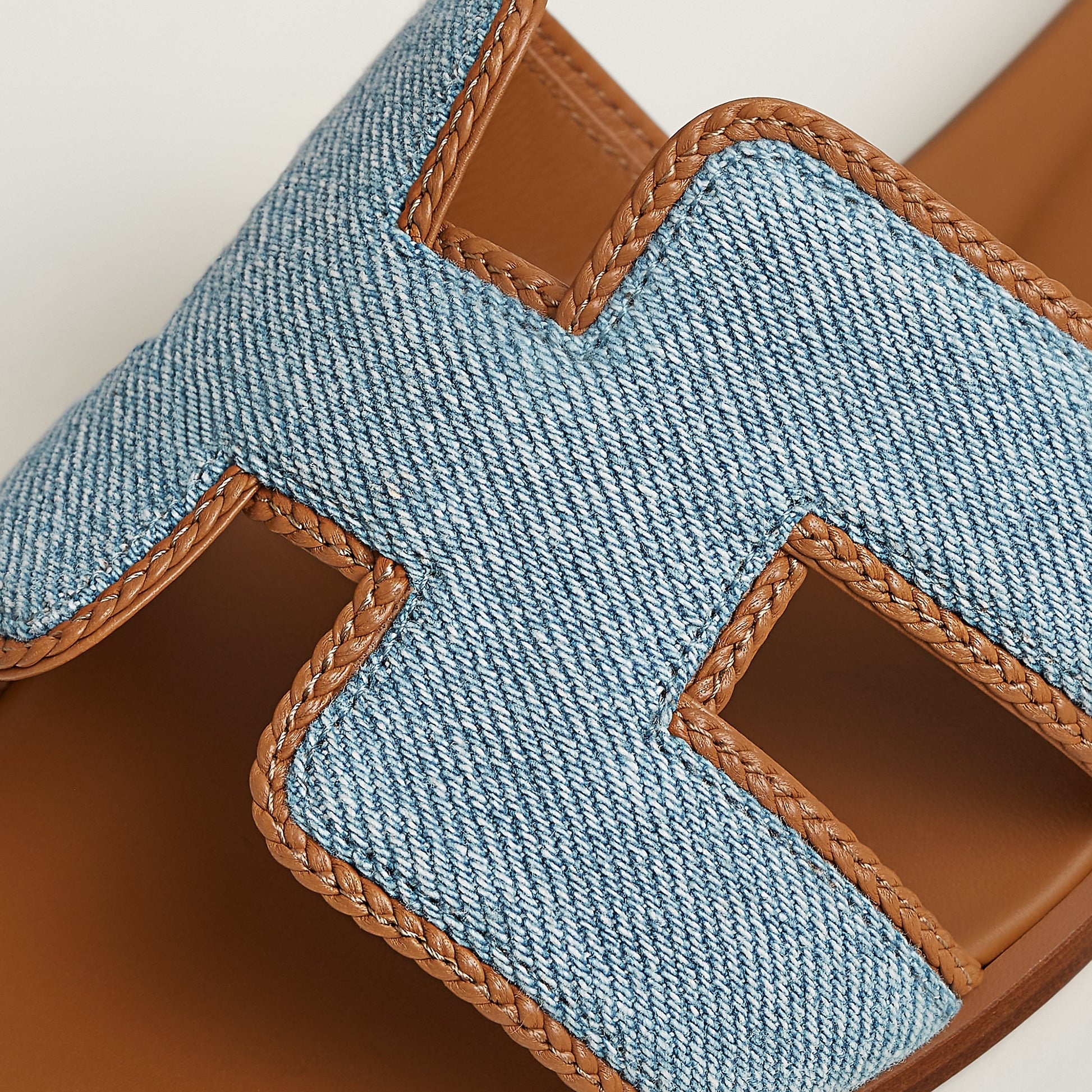 Oran sandal detail view: light blue textile straps with tan leather stitched trim