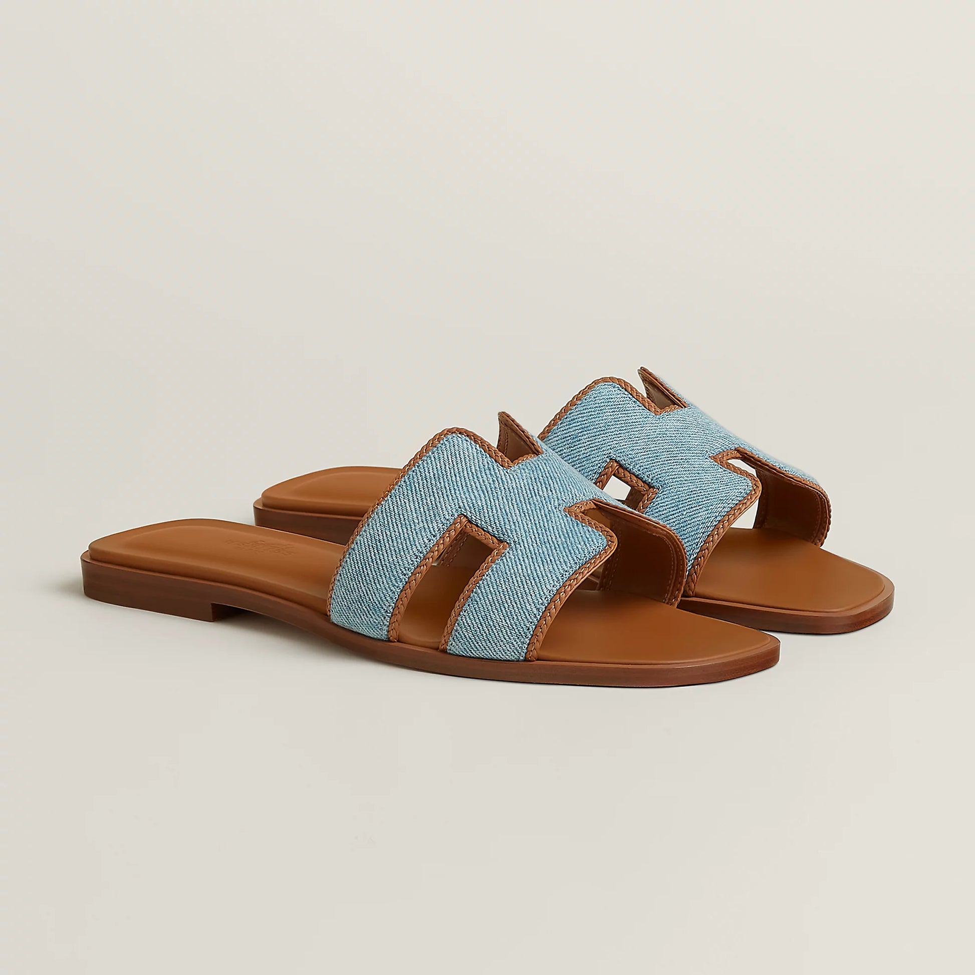 Light blue fabric slide sandal with tan leather straps and flat sole