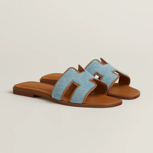 Light blue fabric slide sandal with tan leather straps and flat sole