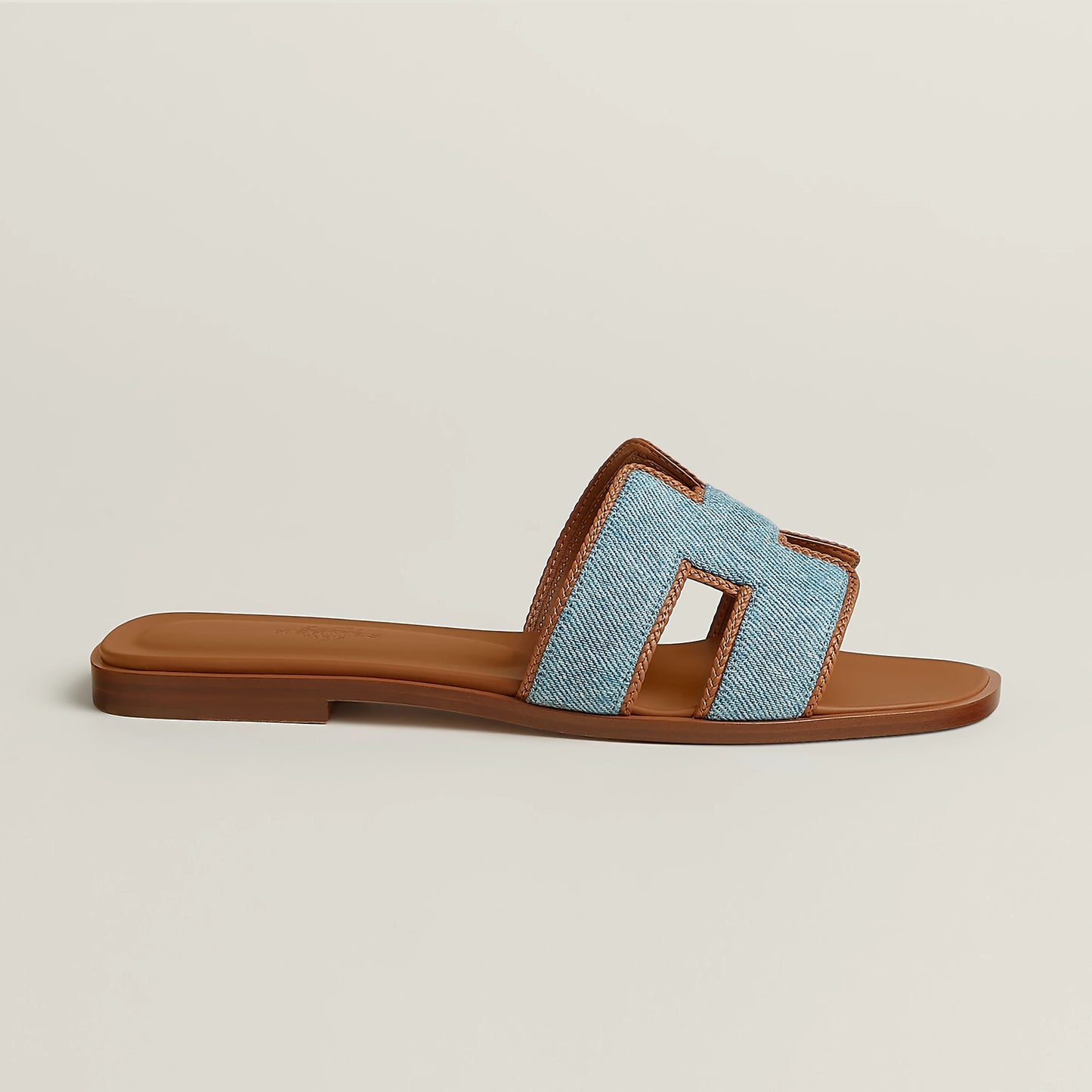 Tan slide sandal with light blue fabric straps and open toe, flat sole