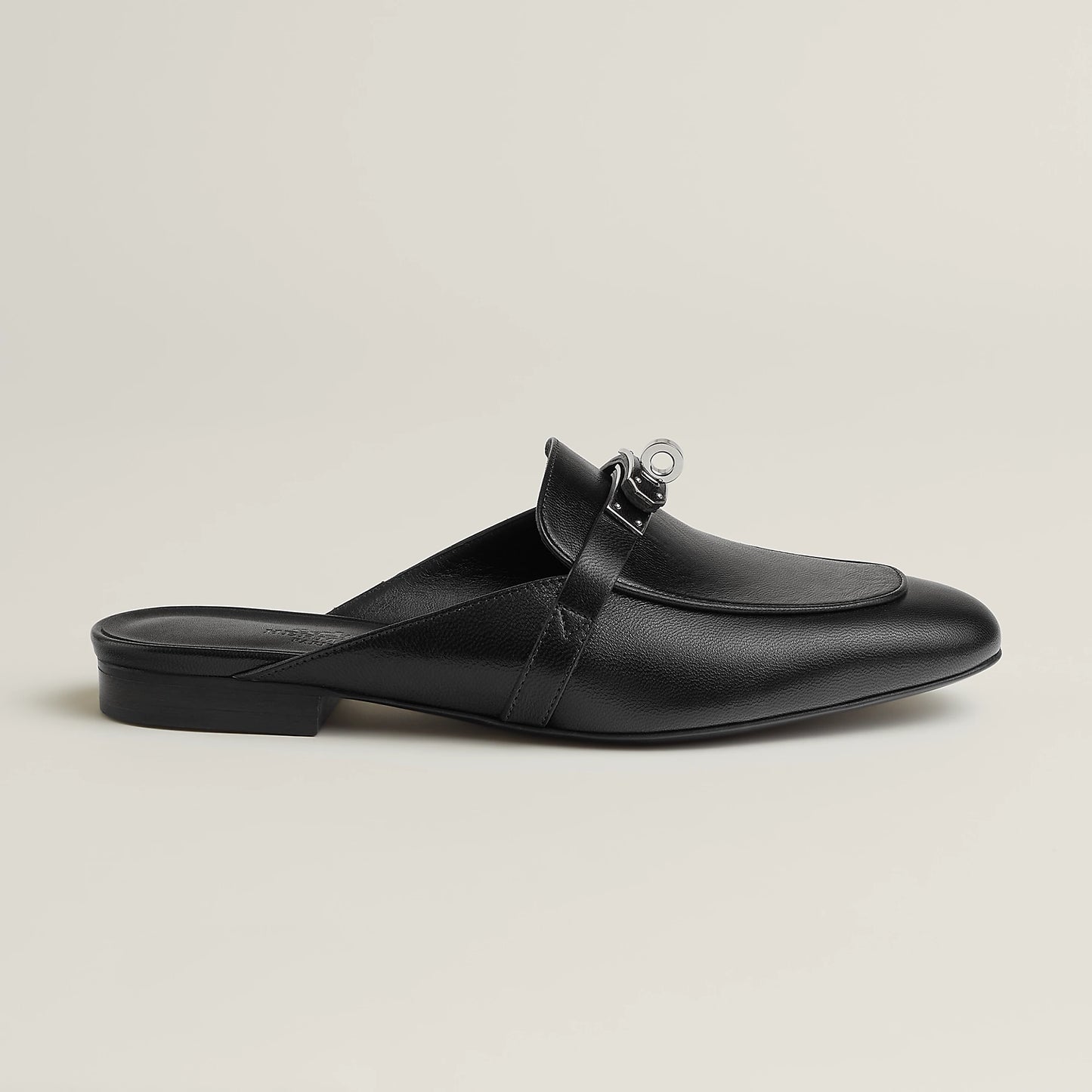Black leather mule with buckle detail, open back, and low flat heel
