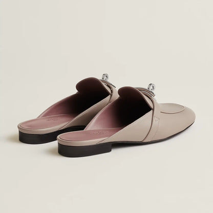 Beige leather mule flats with buckle strap and pink-toned lining