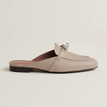 Beige leather mule with buckle strap, open back, and low flat heel