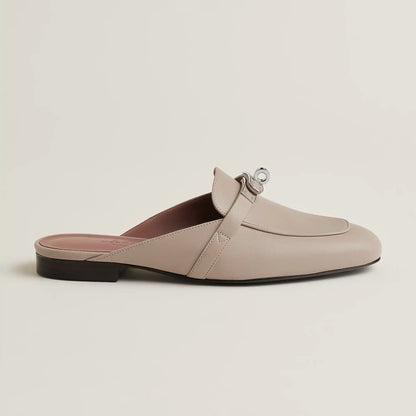 Beige leather mule with buckle strap, open back, and low flat heel
