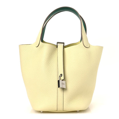 Two-tone leather handbag with yellow body, green top handles, and metal lock clasp.