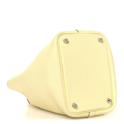 Two-tone leather handbag bottom panel in yellow with metal feet and corner hardware.
