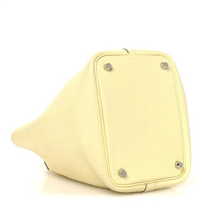 Two-tone leather handbag bottom panel in yellow with metal feet and corner hardware.