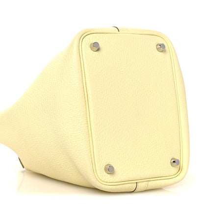 Two-tone leather handbag side panel in yellow with metal corner feet hardware.