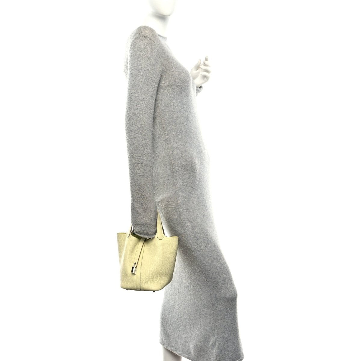 Two-tone leather handbag, yellow body with green handle, carried at side.