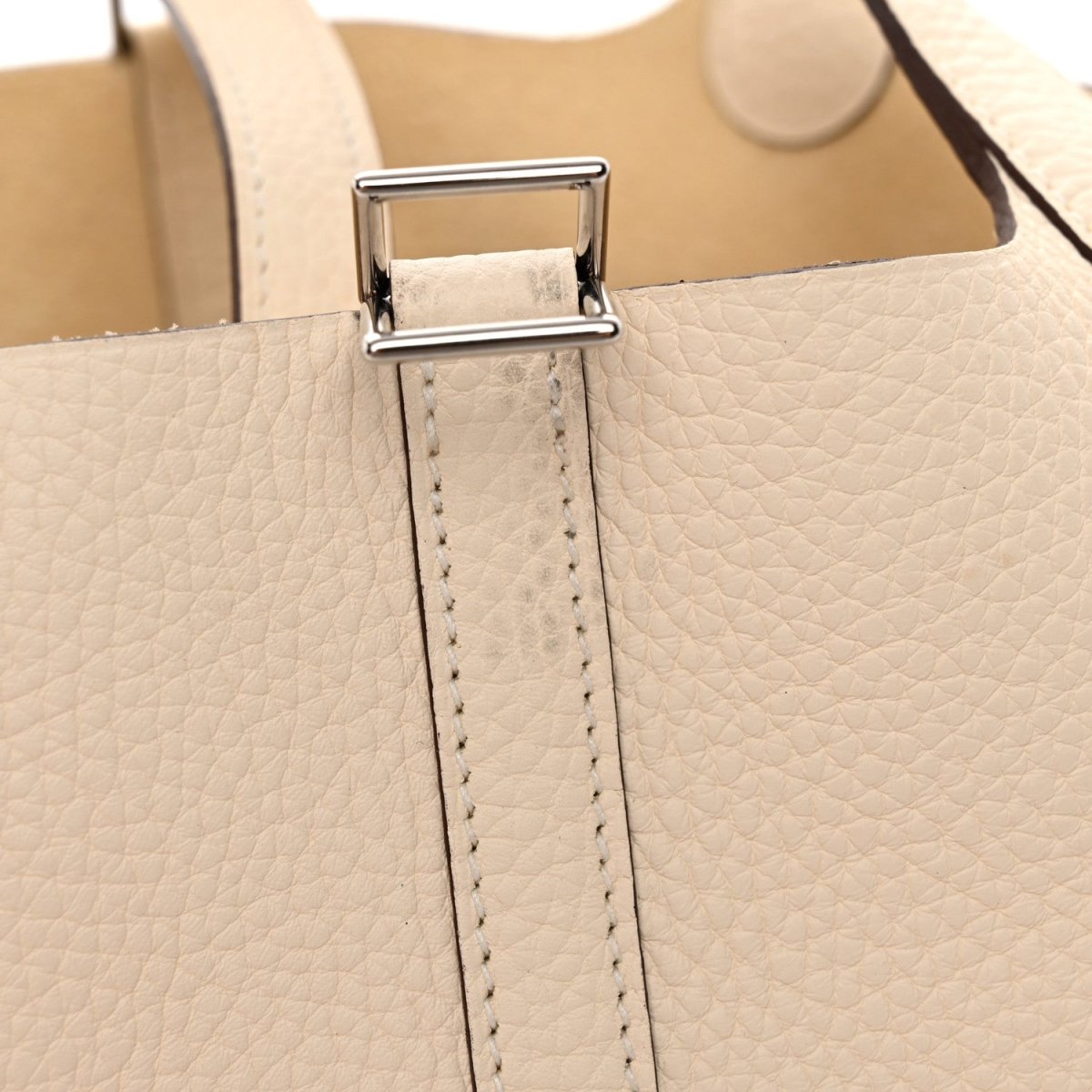 Leather handbag lock detail, light beige with silver clasp and stitched strap