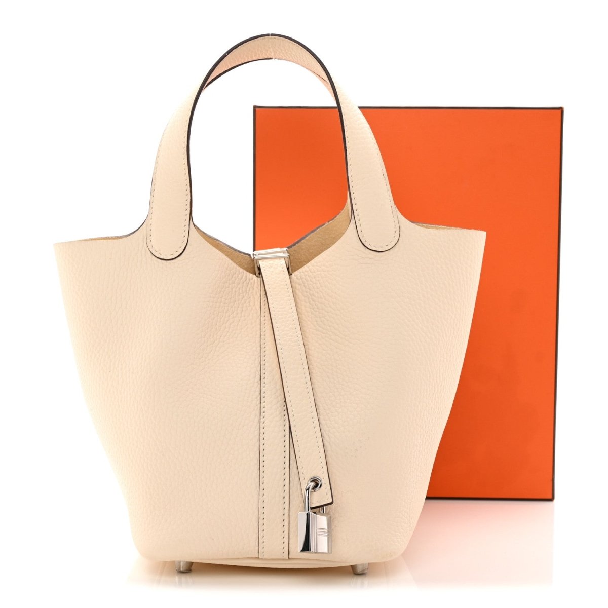 Light beige leather handbag with top handles, central lock strap, side feet