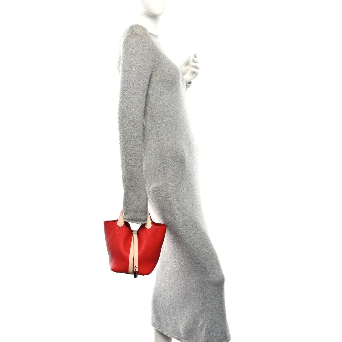 Red top-handle tote bag worn at side, with pale handle straps and lock detail.