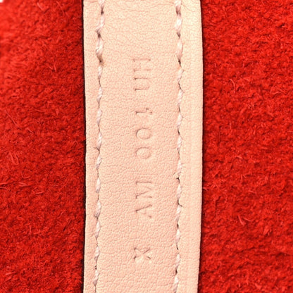 Pale leather strap seam detail on red tote bag.