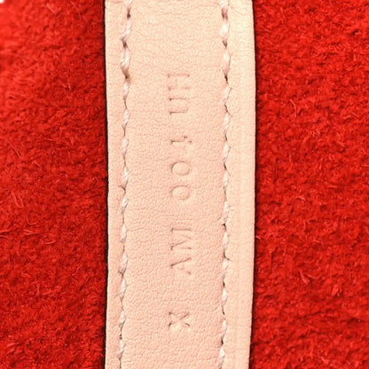 Pale leather strap seam detail on red tote bag.
