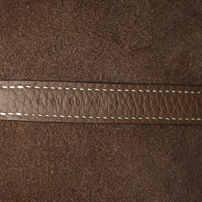 Taupe leather edge with white contrast stitching along the seam.