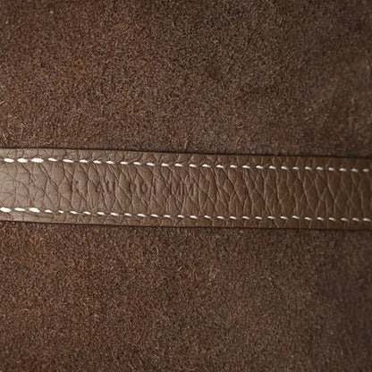 Taupe leather edge with white contrast stitching along the seam.