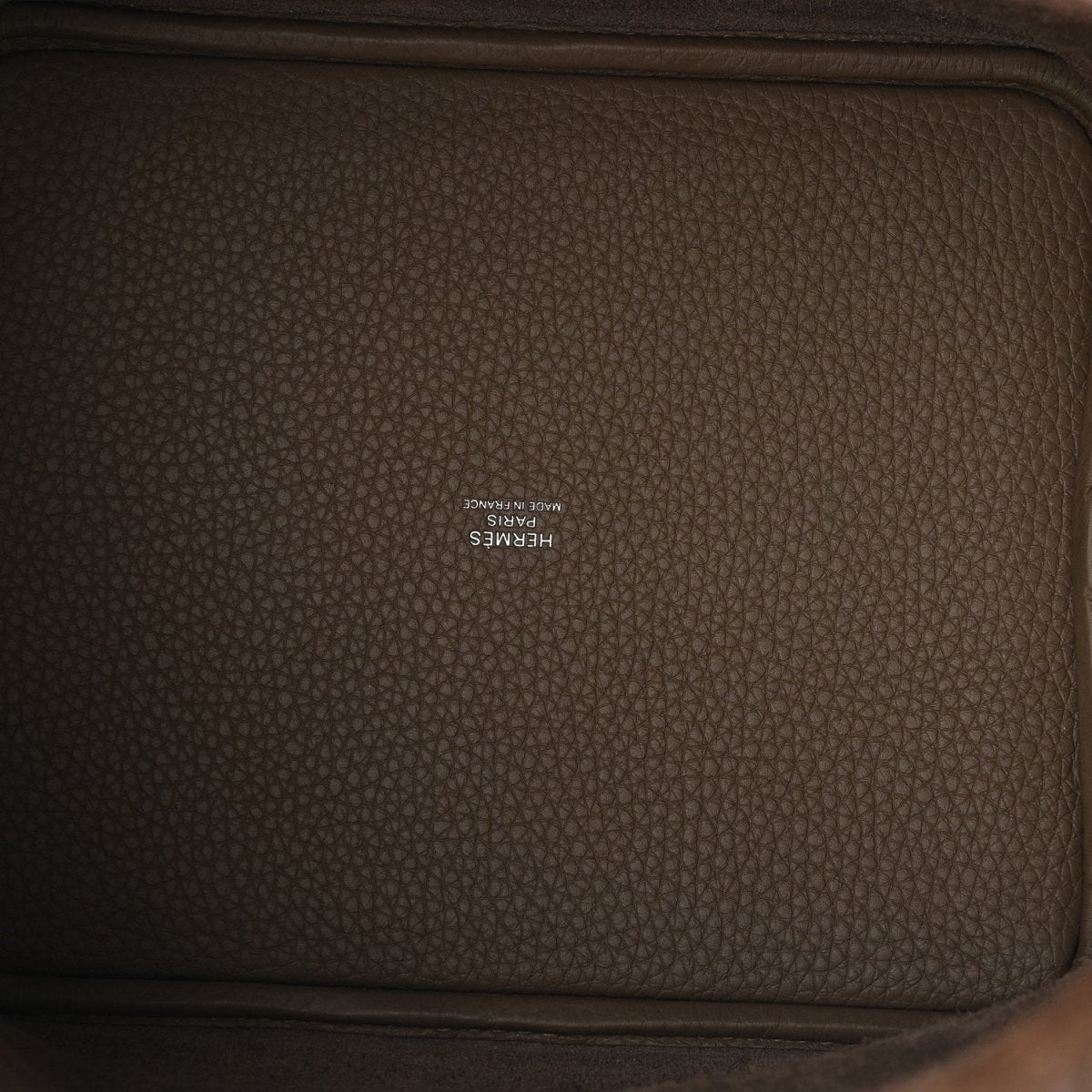 Taupe leather interior panel with embossed brand stamp on textured calfskin.