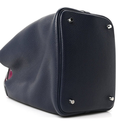 Navy leather bucket bag angled view with magenta lining at opening