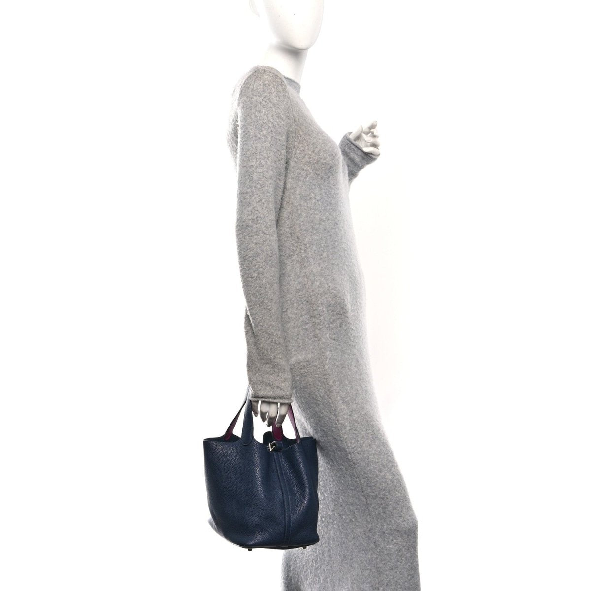 Navy leather bucket bag worn by model, with small top handles and magenta interior