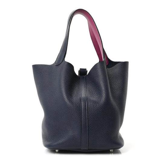 Navy leather bucket bag with top handles and magenta lining, front zip seam