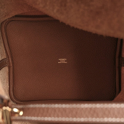 Leather interior of a brown tote bag with stitched trim and Hermes logo.