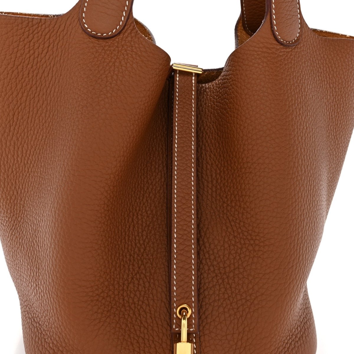 Close-up of brown leather tote with vertical lock zip and stitched edge trim.