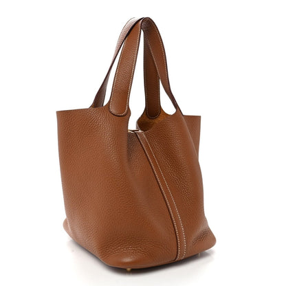 Brown leather tote bag with top handles and structured sides, gold-tone hardware.