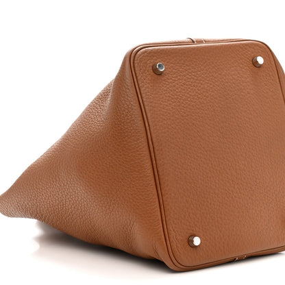 Gold leather tote bag with rounded back panel and silver corner studs