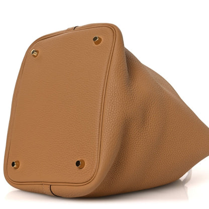 Leather tote with stud corner hardware and triangular silhouette in biscuit